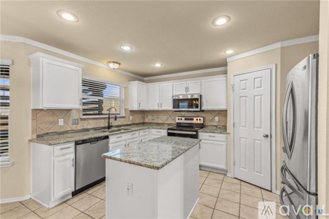 A kitchen with white cabinets and granite countertops.