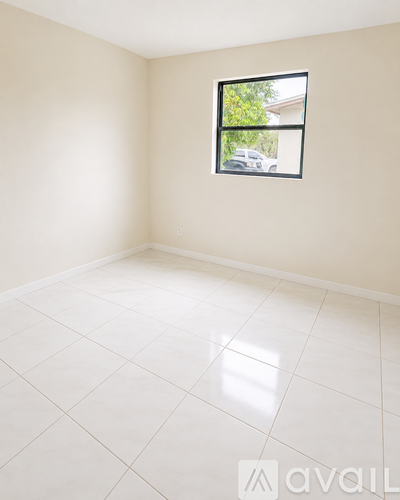 A room with a window and tiled floor.
