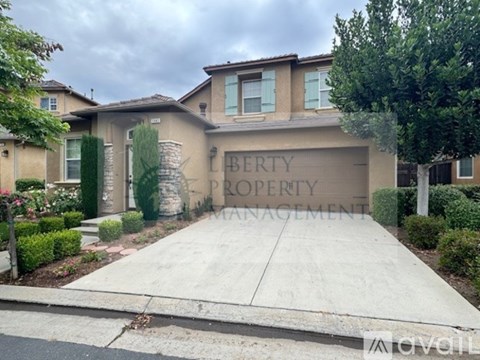 A house with a driveway and a sign that says "Liberty Property Management".