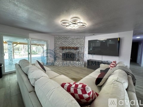 A modern living room with a white sofa and a stone wall.