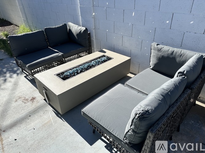 Two grey outdoor couches and a coffee table are on a patio.