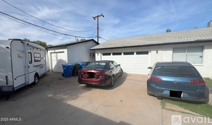 A car is parked in a driveway next to a garage.