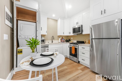 A kitchen with a table set for two and a refrigerator on the right.