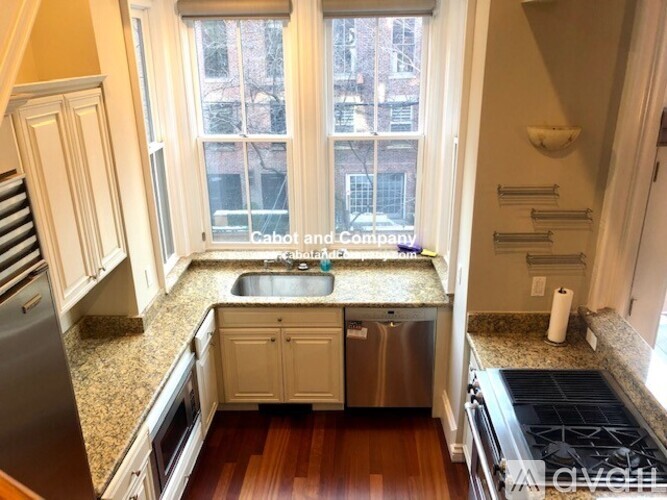 A kitchen with a sink, stove, and cabinets.