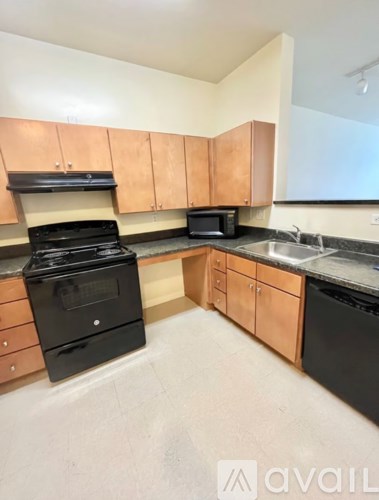 A kitchen with black appliances and wooden cabinets.