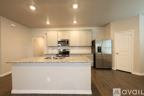 A kitchen with a granite countertop and stainless steel appliances.
