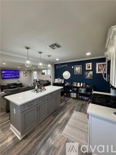 A kitchen with a white countertop and grey cabinets.