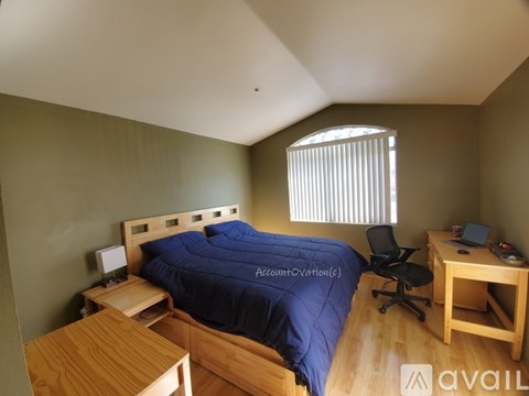 A bedroom with a bed, desk, and chair.