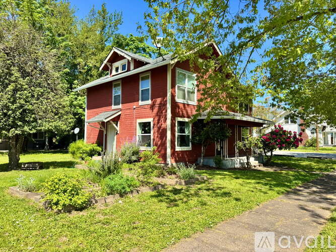 A red house with a well-kept lawn in front.