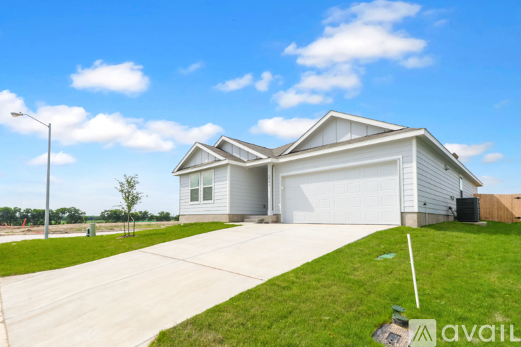 A house with a garage and a driveway in front of it.