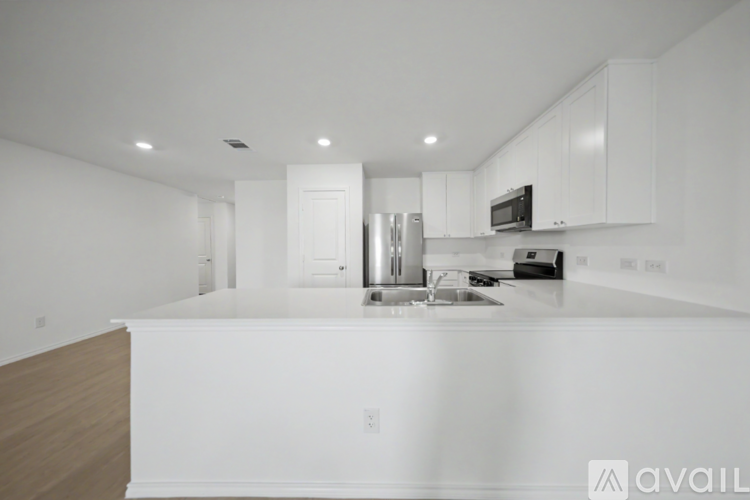 A modern kitchen with white cabinets and a stainless steel refrigerator.