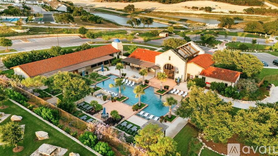 A bird's eye view of a resort with a pool and a building with a red roof.