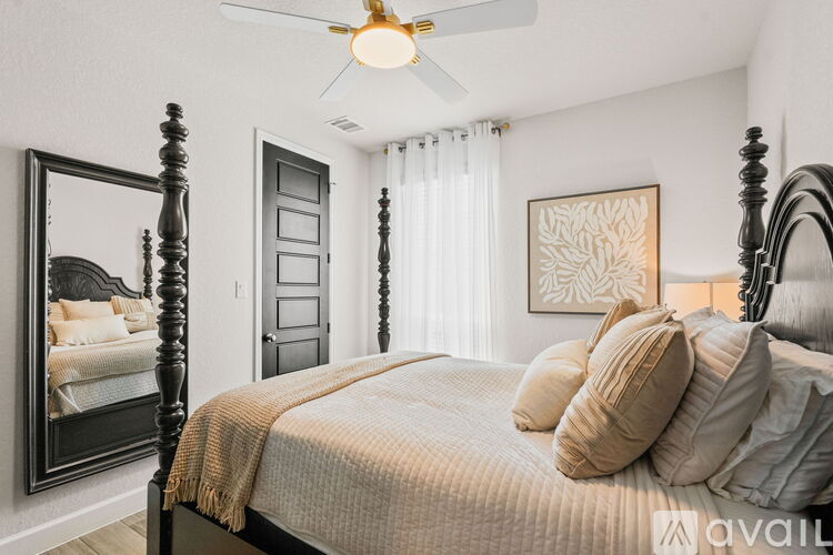 A bedroom with a large bed and a ceiling fan.
