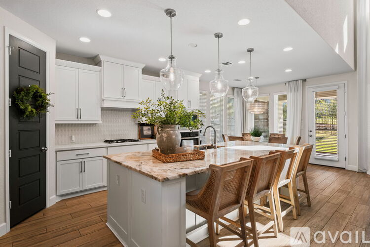 A kitchen with a center island and chairs around it.