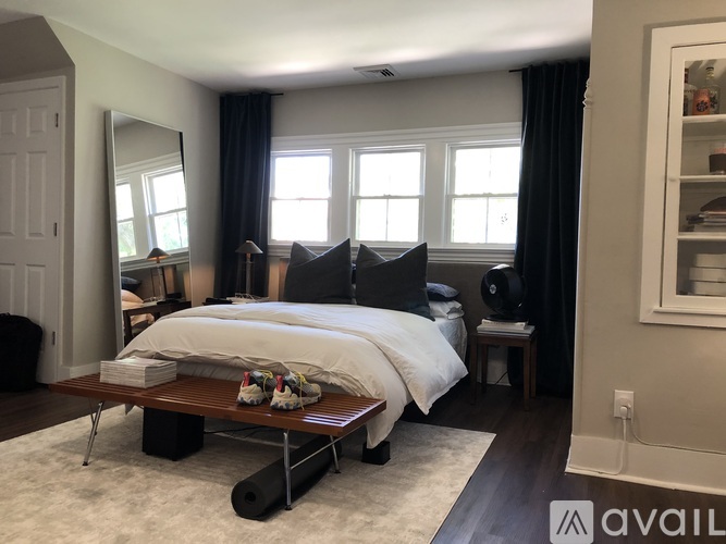 A bedroom with a large bed and a mirror on the wall.