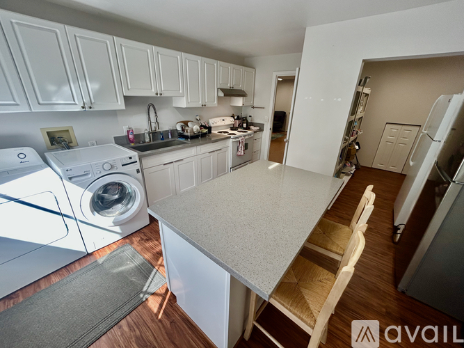 A kitchen with white cabinets and a washing machine.