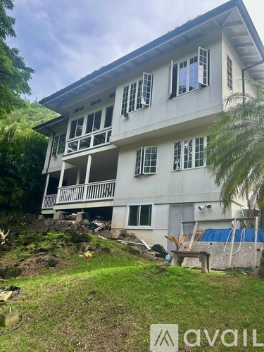 A two-story house with a balcony and a pool in the backyard.