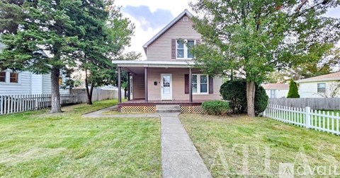 A house with a white picket fence in front.