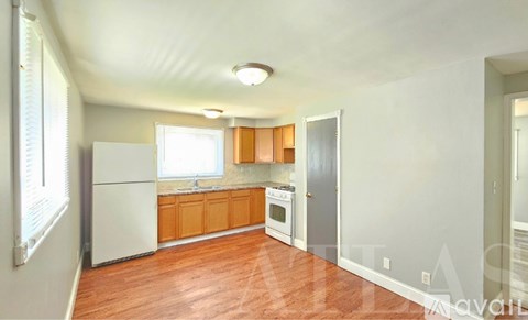A kitchen with wooden cabinets and a white refrigerator.
