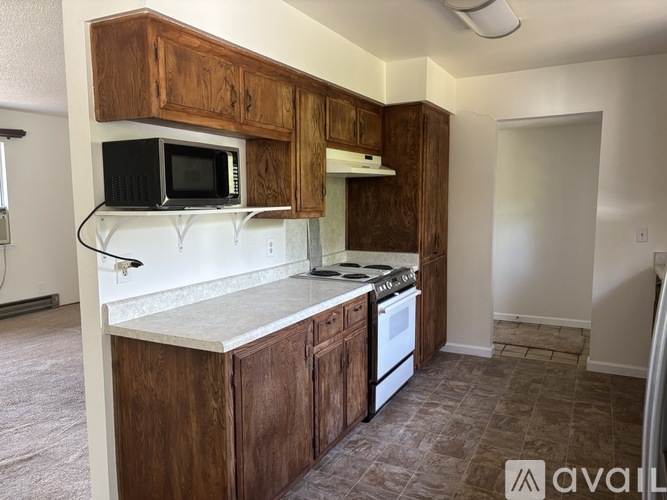A kitchen with wooden cabinets and a white countertop.