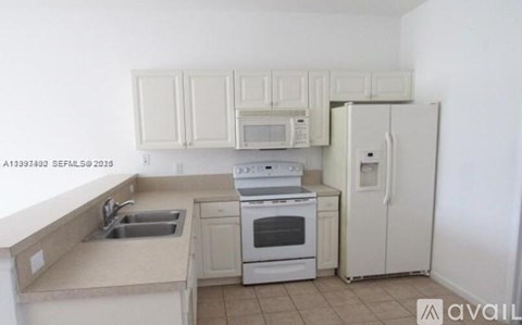 A kitchen with white cabinets and appliances.