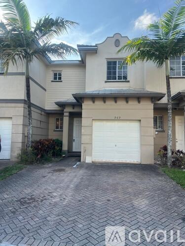 A two-story house with a garage and a driveway.