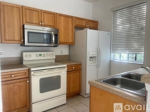 A kitchen with wooden cabinets and white appliances.