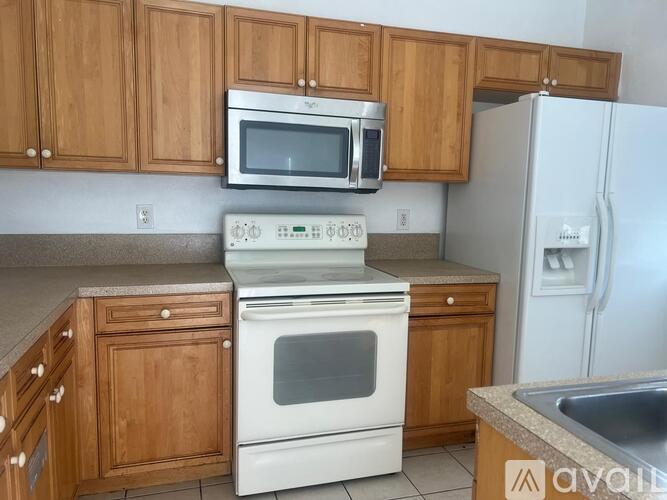 A kitchen with wooden cabinets and a white oven.