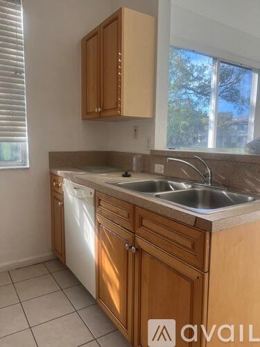 A kitchen with wooden cabinets and a white dishwasher.