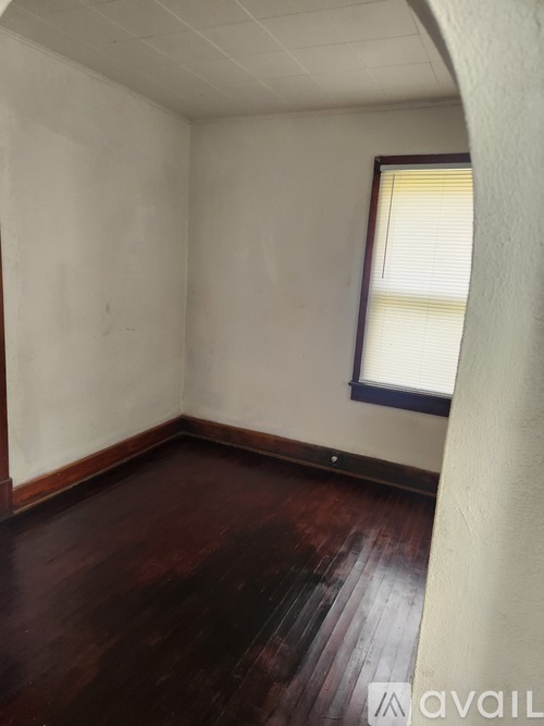 A room with a window and wooden floors.