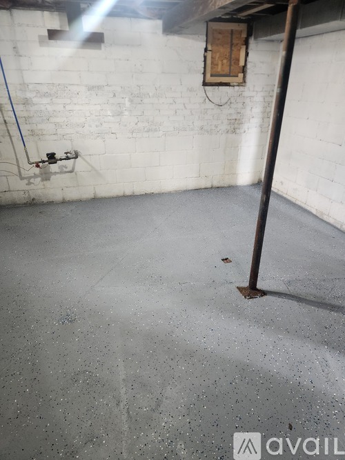 A room with a white brick wall and a concrete floor.