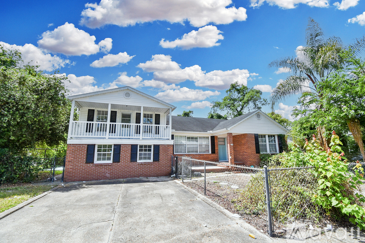 A two-story house with a white porch and black shutters.