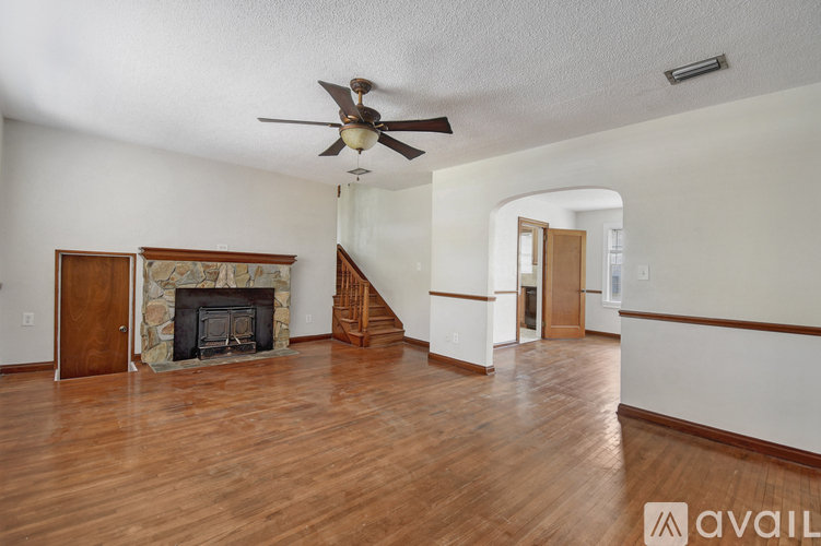 A living room with a fireplace and a fan.