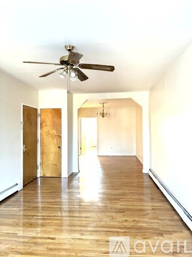 A room with a ceiling fan and wooden floors.