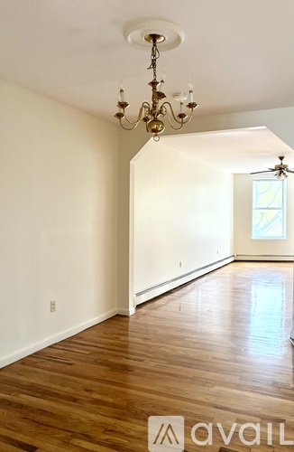 A room with wooden floors and a chandelier.