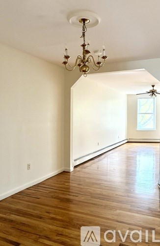 A room with wooden floors and a chandelier.