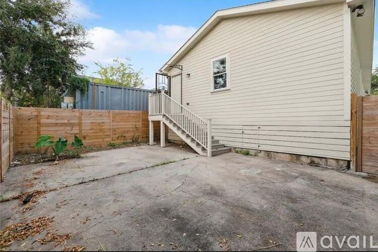 A beige house with a wooden fence and a small porch.