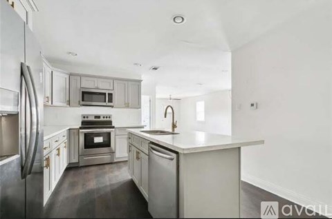 A kitchen with a refrigerator, oven, and sink.