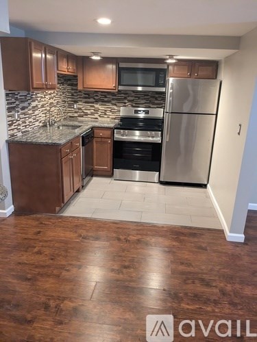 A kitchen with wooden cabinets and a granite countertop.