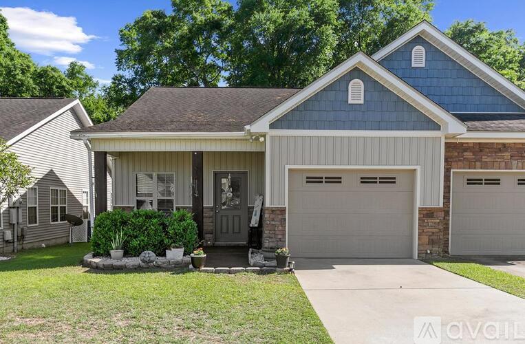 A two-car garage is attached to a house with a front porch.
