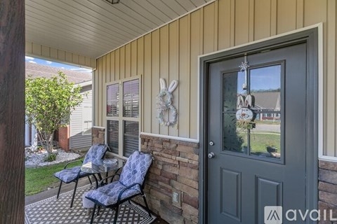 A house entrance with a grey door and a wall with a rabbit decoration.