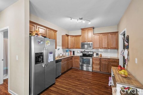 A kitchen with wooden cabinets and a stainless steel refrigerator.