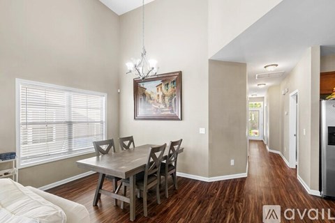 A dining room with a wooden table and chairs.