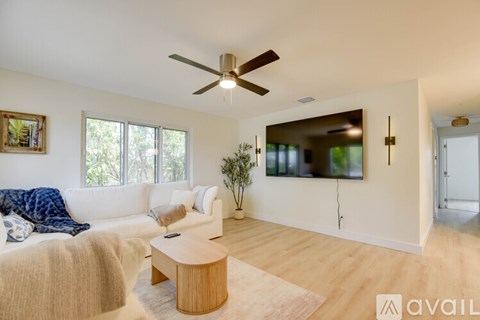 A living room with a white couch and a wooden coffee table.
