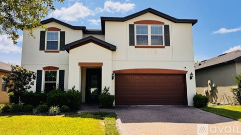 A two-story house with a brown garage door and a driveway.