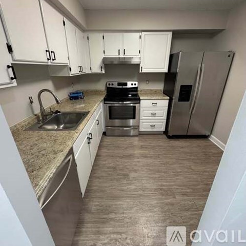 A kitchen with white cabinets and a granite countertop.