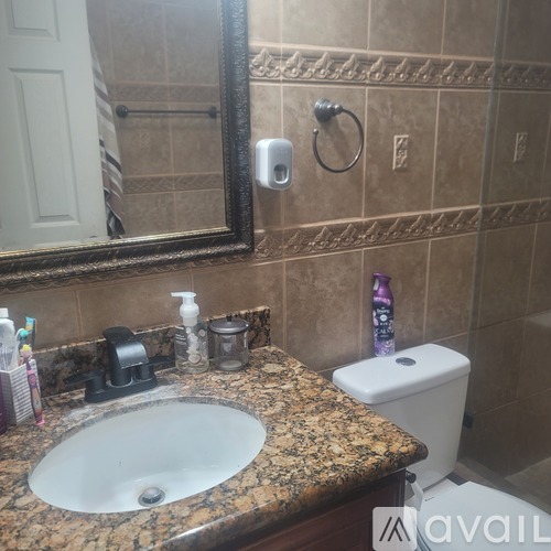 A bathroom with a granite countertop and a white toilet.