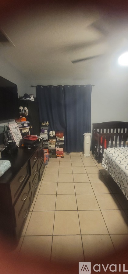A room with a bed, a couch, and a counter with a sink.