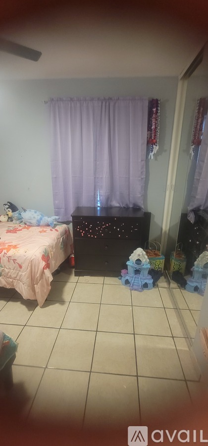 A room with a bed, a dresser, and a window with purple curtains.