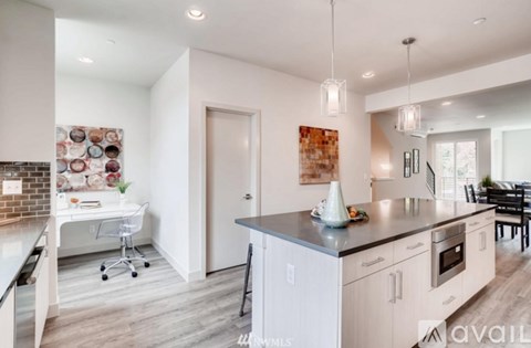 A kitchen with white cabinets and a brick wall.